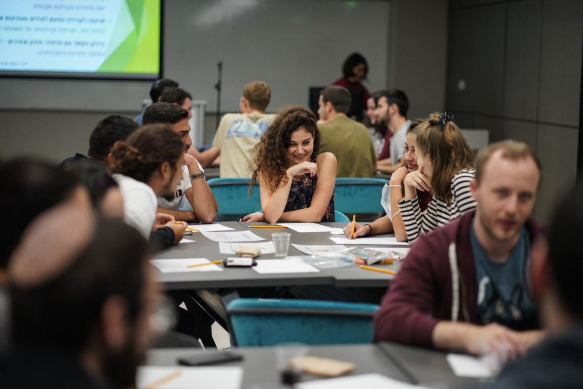 אנשים יושבים בקבוצות קטנות ומתכננים